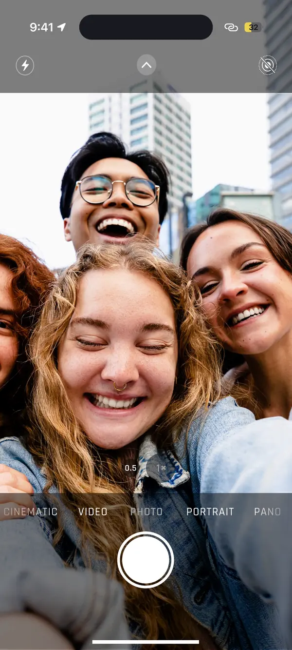 Quatre amis souriants dans le cadre de l’appareil photo, au moment de prendre le selfie qui les ajoutera sur Gullu.